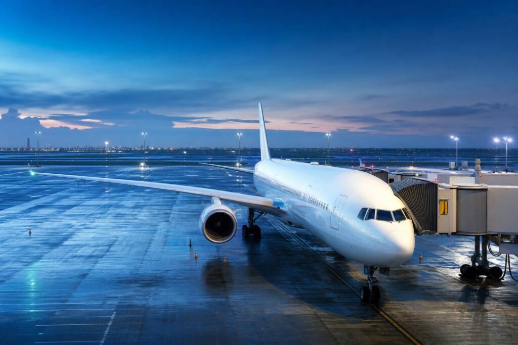 Avion de ligne long-courrier blanc sans logo sur un tarmac au crépuscule