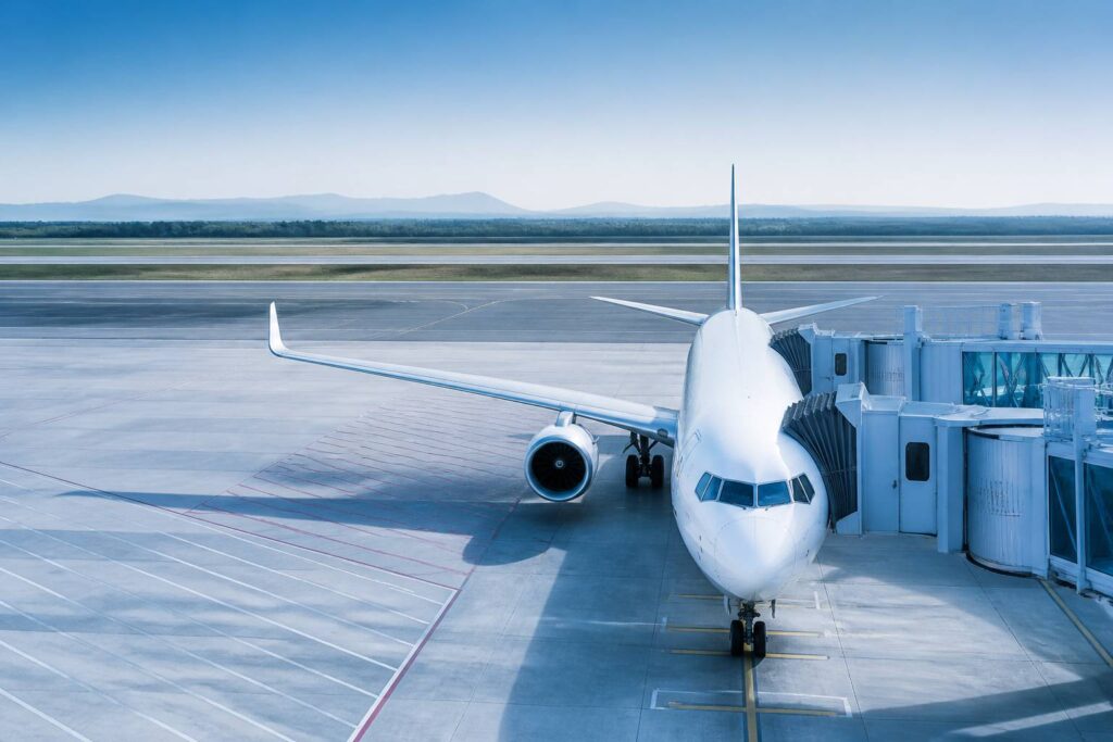 Avion de ligne garé sur un tarmac avec passerelle d'embarquement
