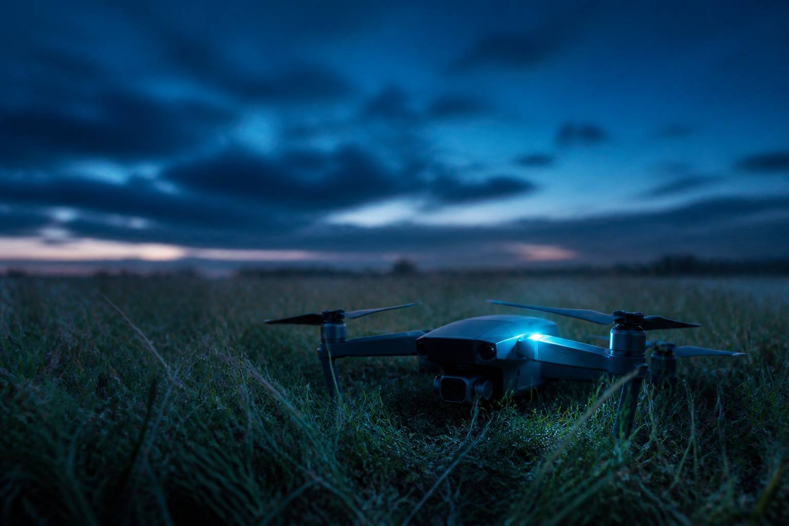Drone posé dans un champ de hautes herbes avec une LED allumée