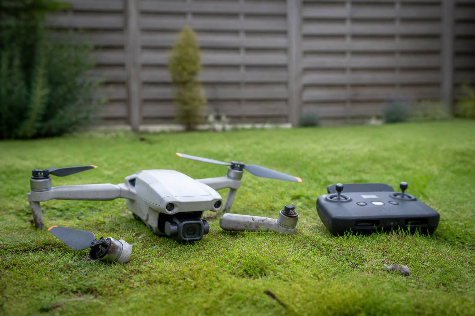 Drone tombé dans un jardin avec sa radiocommande dans l'herbe