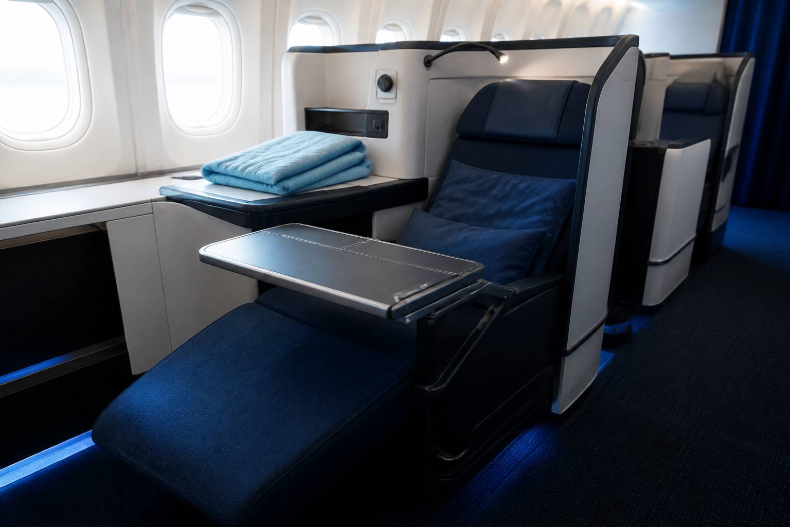 Siège d'avion premium inclinable avec repose-jambes et tablette dans une cabine claire